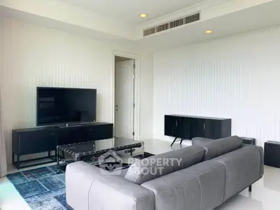 Modern living room with sleek gray sofa and large flat-screen TV