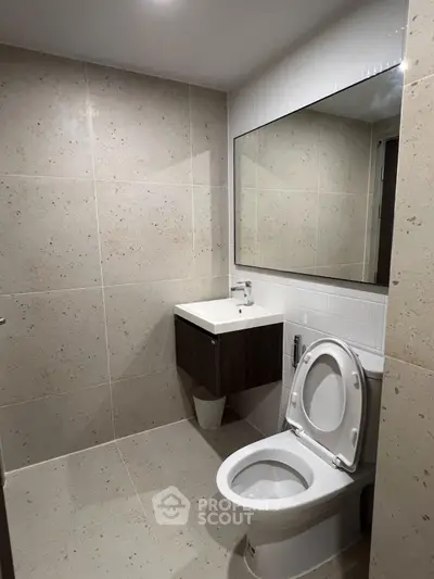 Modern bathroom with sleek fixtures and large mirror in a contemporary home.