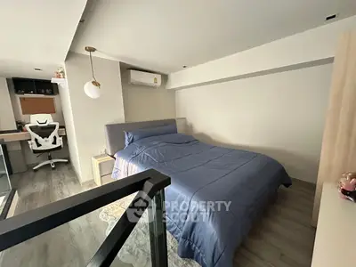 Modern bedroom with stylish decor and workspace in a cozy loft setting.