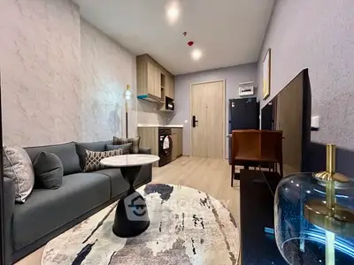 Modern living room with stylish furniture and open kitchen layout in a cozy apartment.