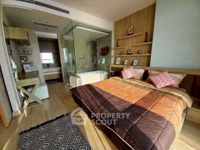 Luxurious bedroom with modern glass-enclosed bathroom and stylish decor