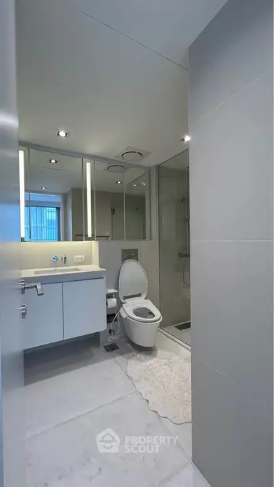 Modern bathroom with sleek fixtures and large mirrors in a contemporary apartment.
