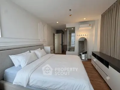 Spacious modern bedroom with elegant decor and ample natural light