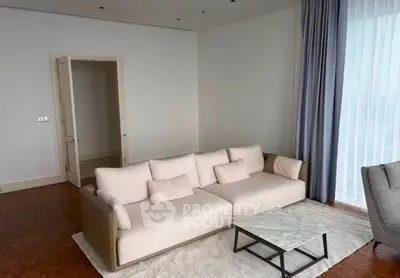 Spacious modern living room with elegant sofa and floor-to-ceiling windows.