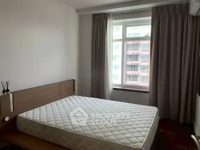 Cozy bedroom with large window and modern decor in urban apartment