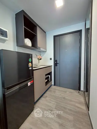Modern compact kitchen with sleek black fridge and stylish cabinetry