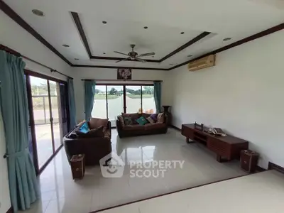 Spacious living room with large windows and elegant furniture, perfect for relaxation.
