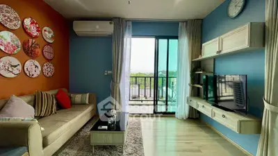 Stylish living room with vibrant decor and balcony view, perfect for modern living.
