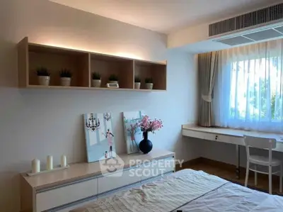 Charming bedroom with modern decor, natural light, and stylish shelving.
