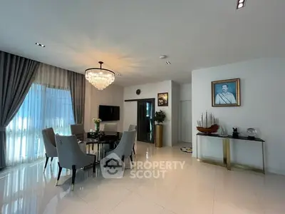 Elegant dining area with chandelier and modern decor in a spacious living room.