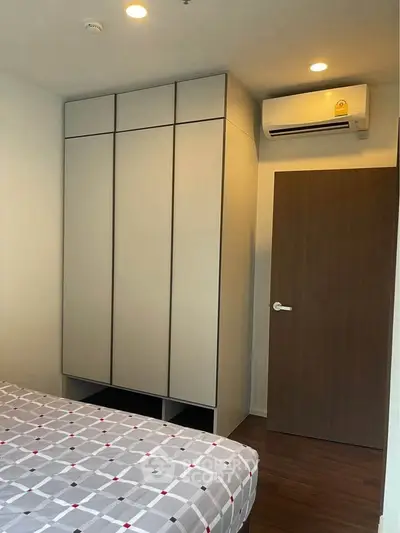 Modern bedroom with built-in wardrobe and air conditioning unit