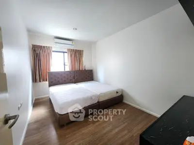 Spacious bedroom with twin beds and modern decor in a bright apartment.