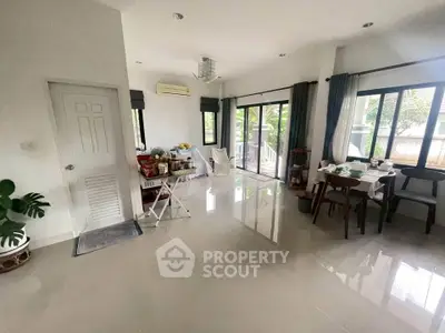 Spacious living area with modern decor and large windows offering natural light.