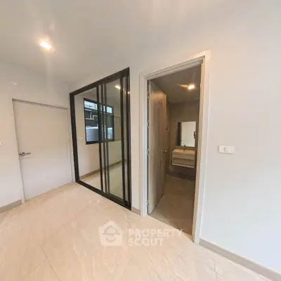 Modern interior with sleek bathroom and glass partition in a contemporary apartment.