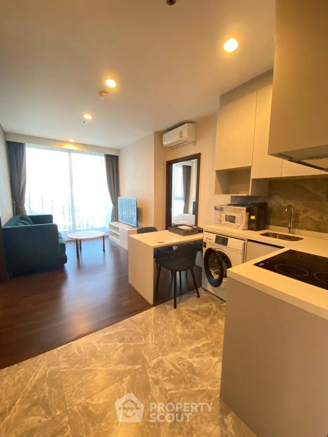 Modern open-plan living room and kitchen with stylish furniture and appliances