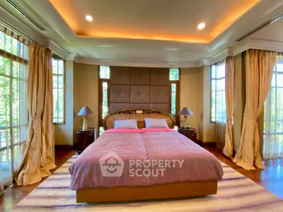 Luxurious bedroom with elegant decor and large windows offering natural light.