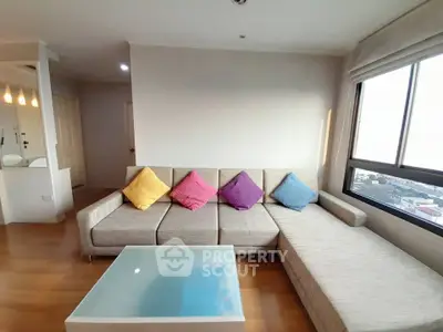 Spacious living room with modern sectional sofa and city view, perfect for relaxation and entertaining.