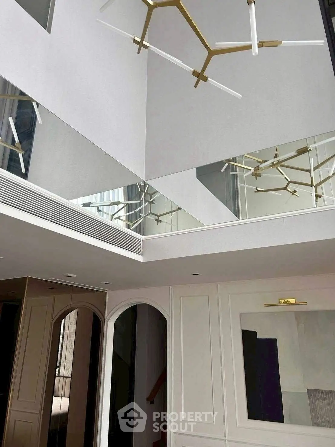 Luxurious modern interior with high ceiling and elegant lighting fixtures.