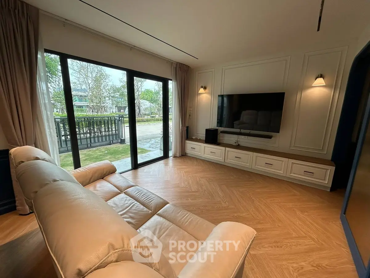 Spacious living room with elegant decor and large sliding glass doors opening to a serene garden view.