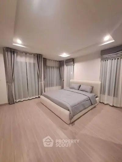 Spacious modern bedroom with elegant curtains and cozy bed