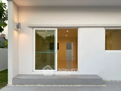 Modern minimalist exterior with sliding glass door and ambient lighting