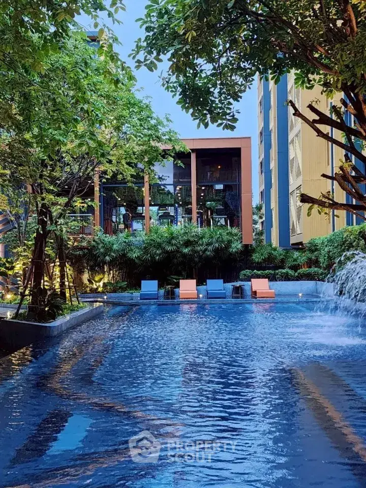Luxurious apartment complex with serene pool and lush greenery, perfect for relaxation and leisure.