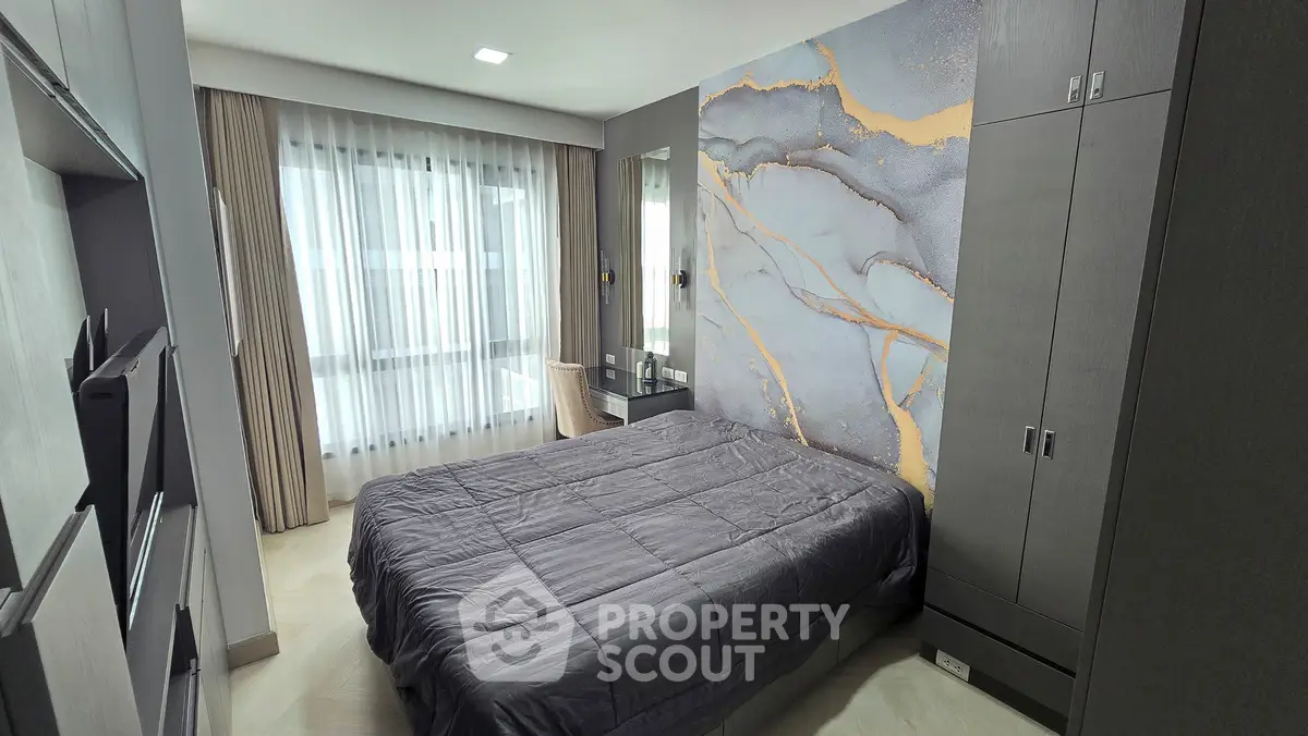 Modern bedroom with stylish marble accent wall and sleek furniture design.