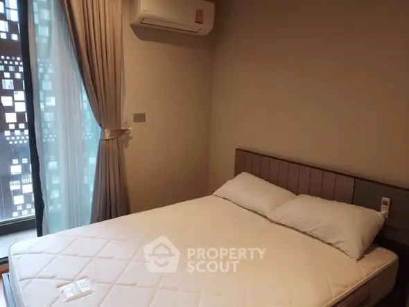 Cozy bedroom with modern air conditioning and natural light from large window.