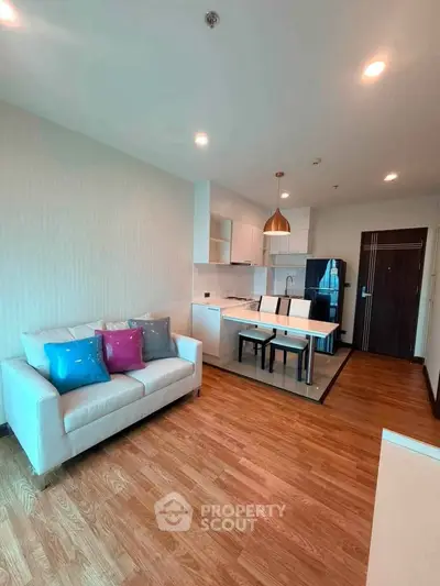 Modern open-layout living room with stylish kitchen and cozy seating area.