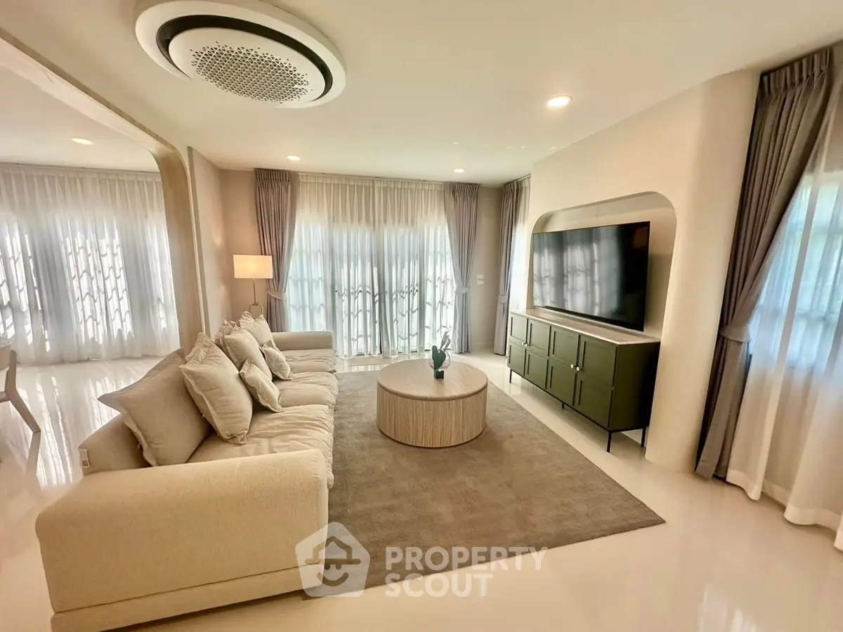Luxurious living room with modern decor, plush sofa, and large TV, perfect for relaxation and entertainment.