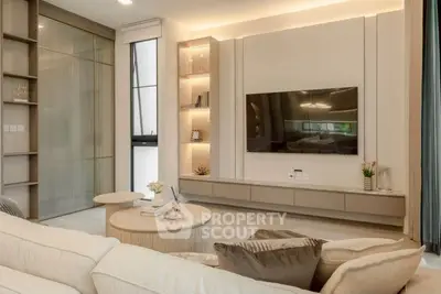 Modern living room with sleek design, built-in shelves, and wall-mounted TV for luxury living.