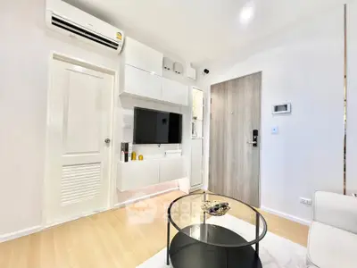 Modern living room with sleek white furniture and wall-mounted TV