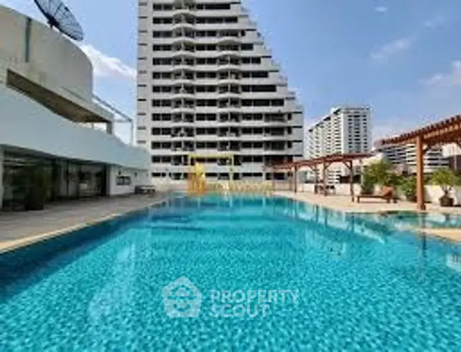 Inviting residential complex with a large outdoor swimming pool, modern high-rise buildings, and a sunny sky, perfect for urban living with luxurious amenities.