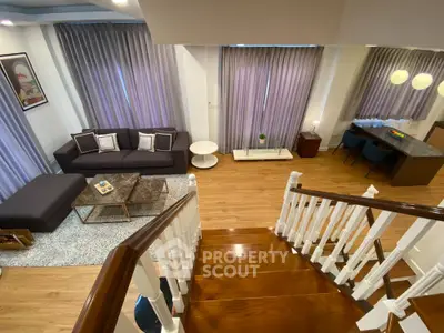 Elegant living room with modern decor and wooden staircase, perfect for stylish urban living.