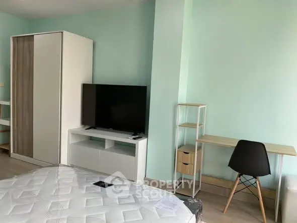 Modern bedroom with minimalist furniture and a sleek TV setup.