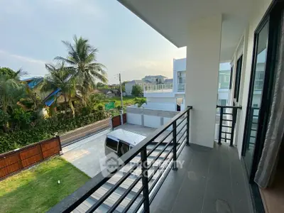 Spacious balcony with scenic view of modern residential area and lush greenery.
