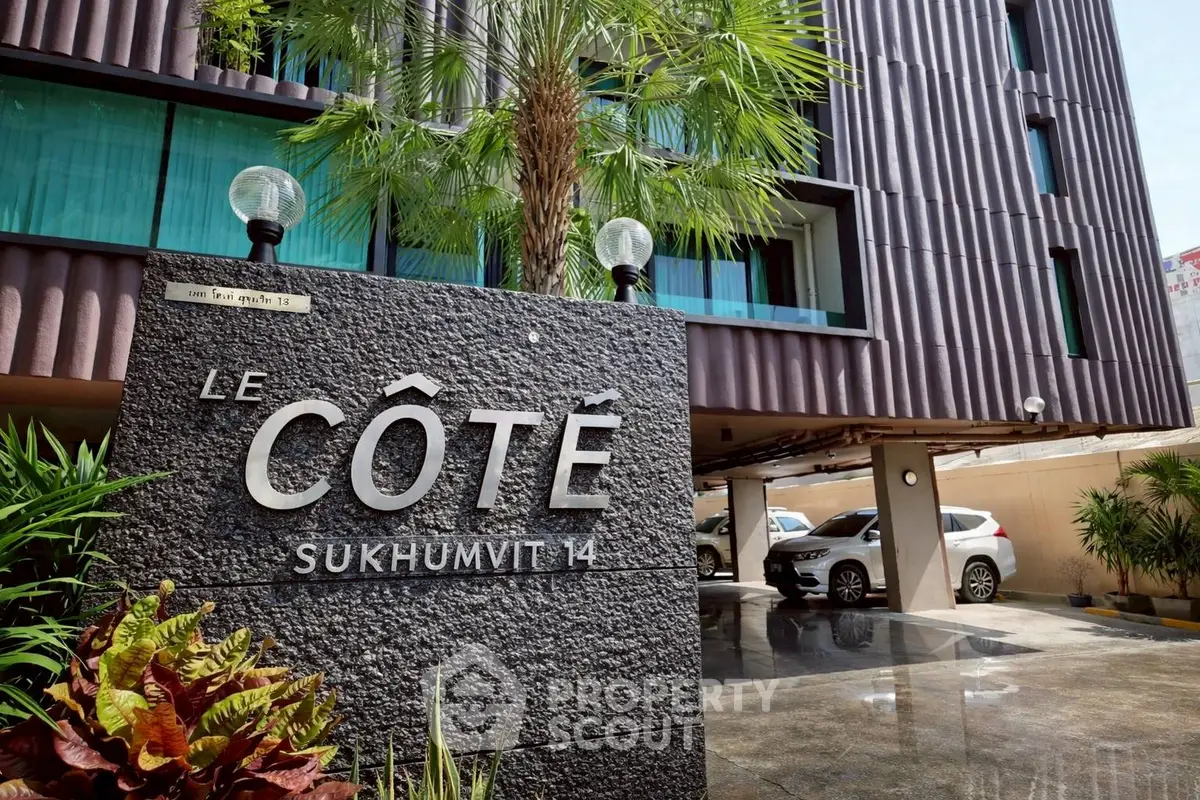 Modern condominium entrance with sleek design and lush greenery at Le Côté Sukhumvit 14.