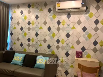 Stylish living room with modern geometric wallpaper and cozy sofa, perfect for relaxation.