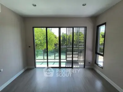 Spacious room with large windows and balcony view, perfect for natural light lovers.