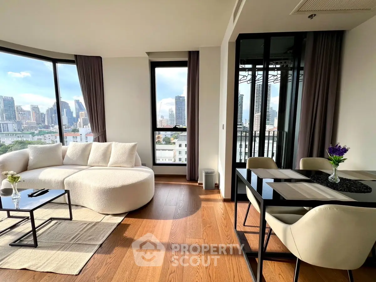 Modern living room with city view, elegant furniture, and natural light.