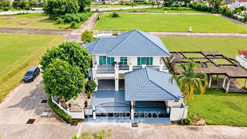 Stunning two-story house with blue roof and spacious driveway in lush green surroundings.
