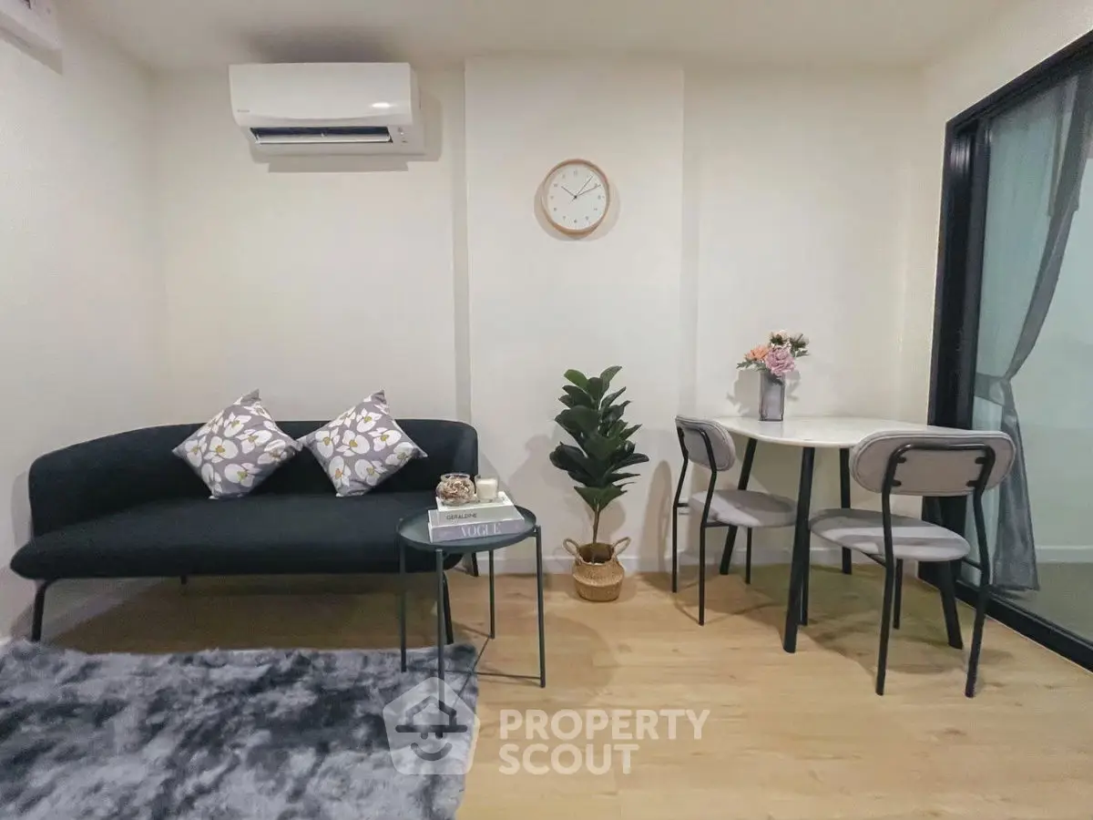 Cozy living room with modern decor and dining area, featuring a plush rug and stylish furniture.