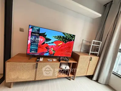 Modern living room with stylish TV stand and large flat-screen TV, perfect for entertainment.