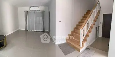 Spacious interior with modern staircase and tiled flooring, perfect for contemporary living.