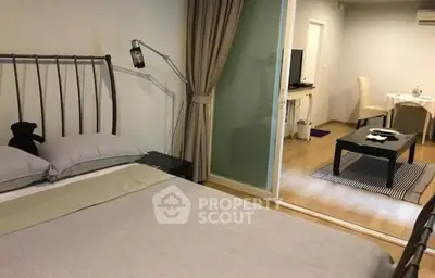 Cozy bedroom with modern decor and view into stylish living area