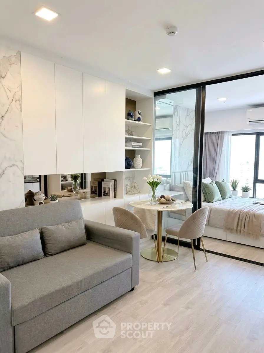 Modern open-plan living room with stylish decor and cozy bedroom view
