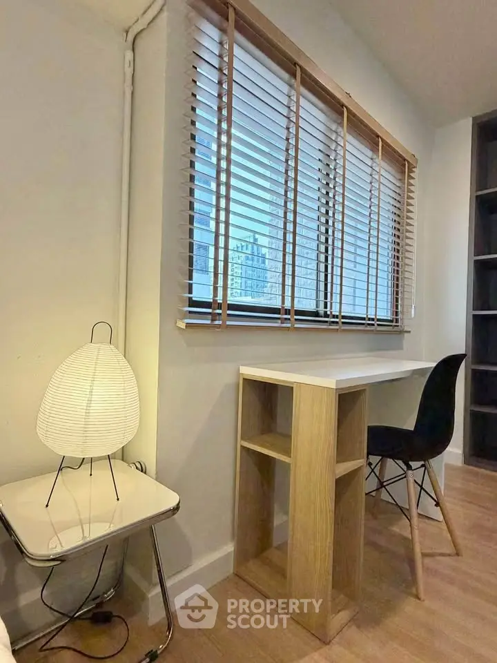Cozy study nook with modern desk and chair by window with blinds, perfect for productivity.