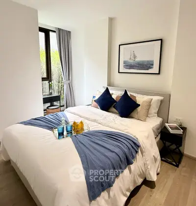 Elegant bedroom with stylish decor and large window offering natural light