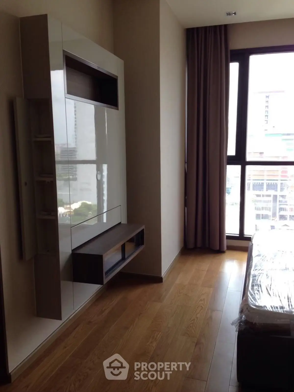 Modern bedroom with sleek built-in storage and large window view.