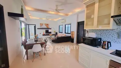 Spacious open-plan living room and kitchen with modern decor and ample natural light.